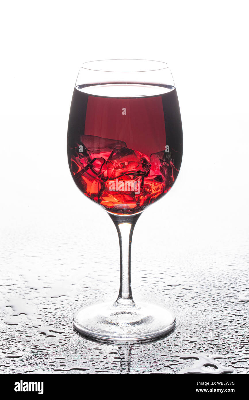 Bicchiere di vino con cristalli di ghiaccio su un sfondo di vetro Foto Stock