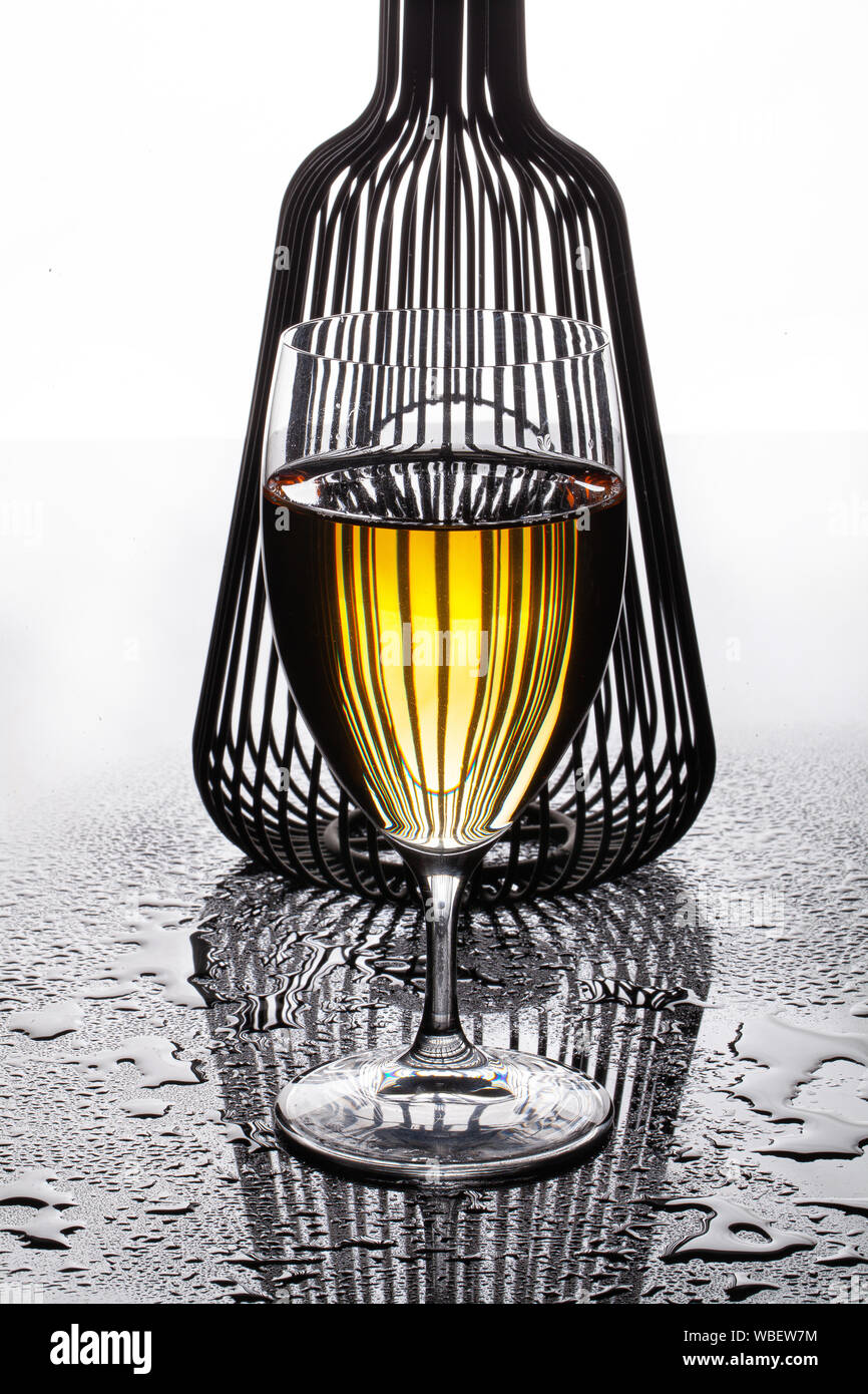 Bicchiere di vino bianco e di forma su un sfondo di vetro Foto Stock