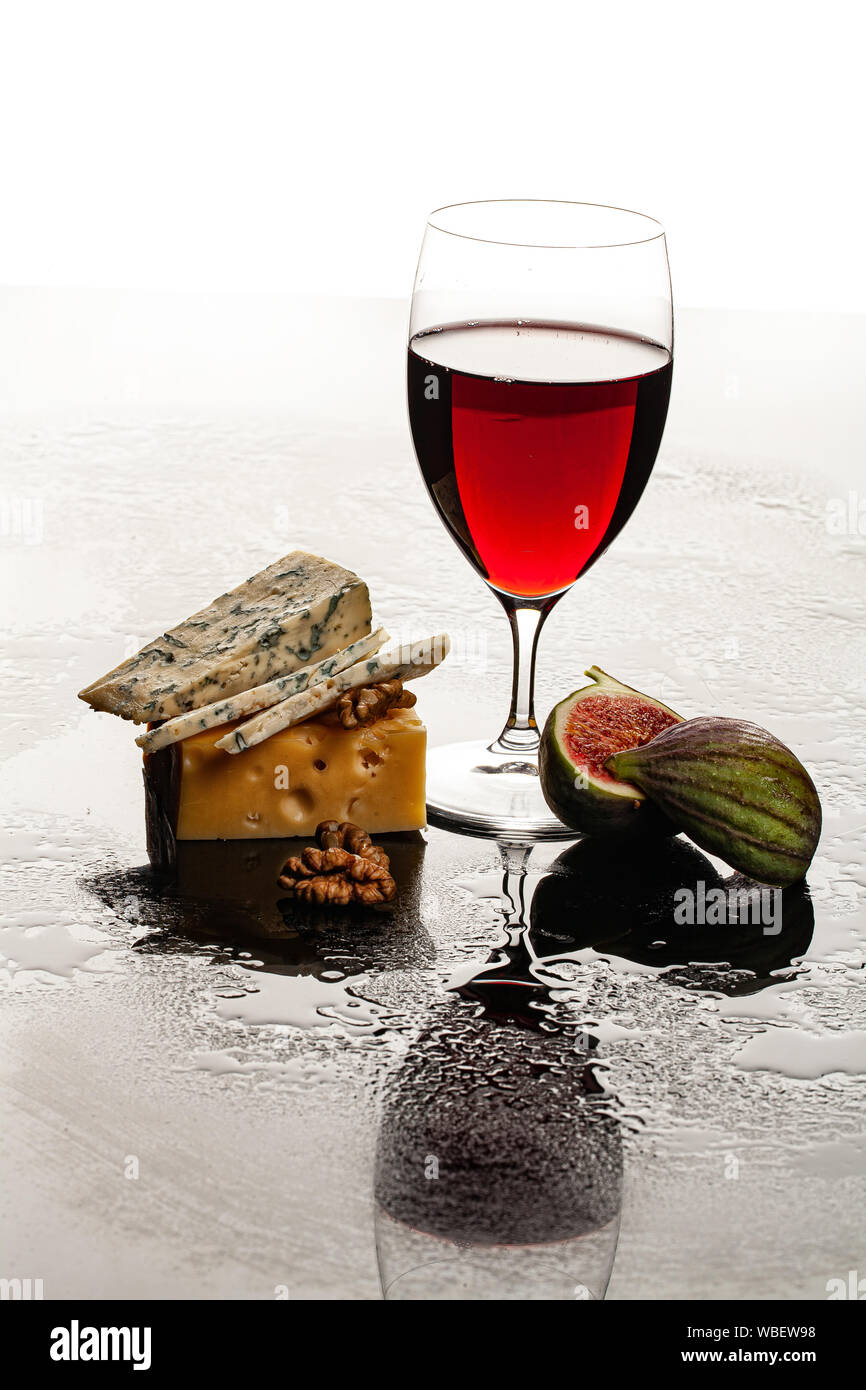 Bicchiere di vino, formaggio e la figura su un sfondo di vetro Foto Stock