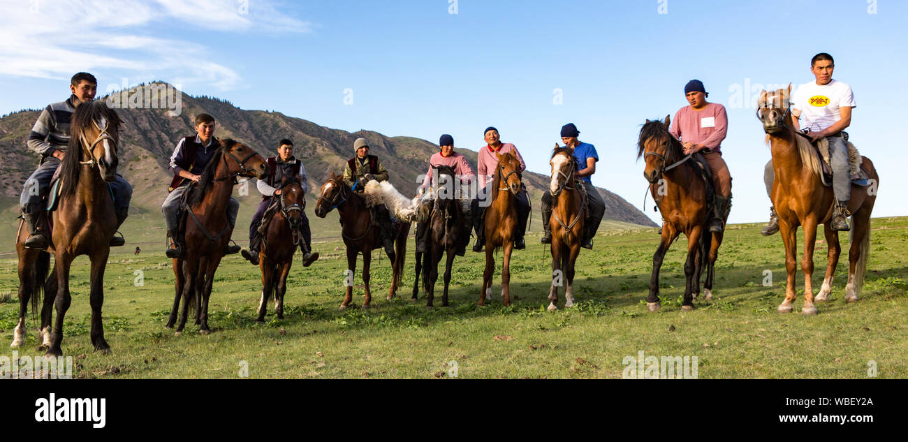 Issyk Kul, Kirghizistan - 28 Maggio 2017 - i giocatori Buzkashi line up prima del loro gioco in cui essi cercano di gettare una testa di capra in un anello di obiettivo Foto Stock