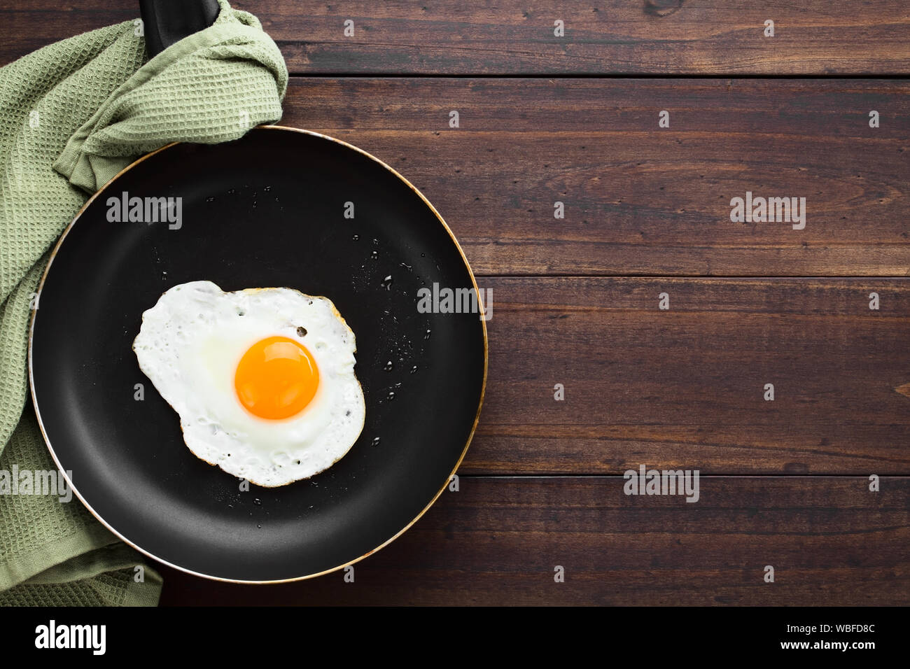 Una fresca uovo fritto sunny side fino in padella, fotografato il sovraccarico con copia spazio sul lato destro Foto Stock