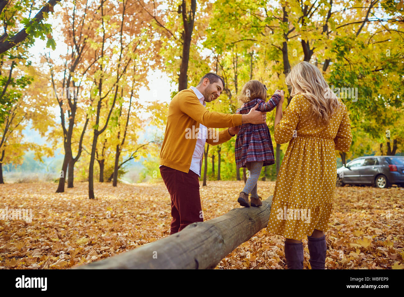 La famiglia gioca con la loro figlia su la natura in autunno Foto Stock
