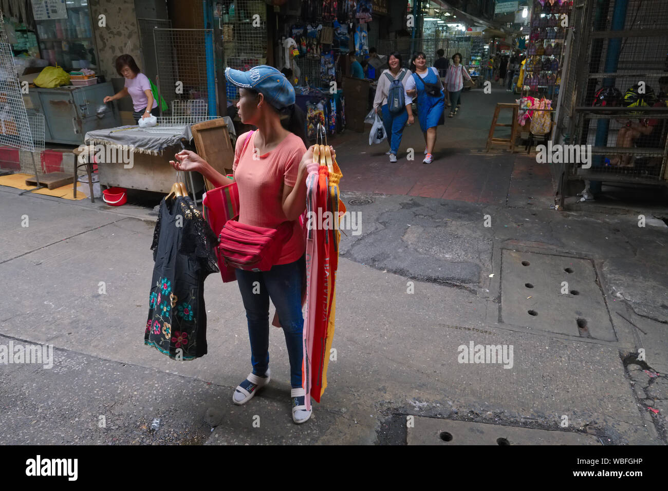 Su una prima mattina, un mobile i fornitori di abbigliamento è guardare fuori per i clienti a Sampeng Lane in Chinatown, Bangkok, Thailandia Foto Stock