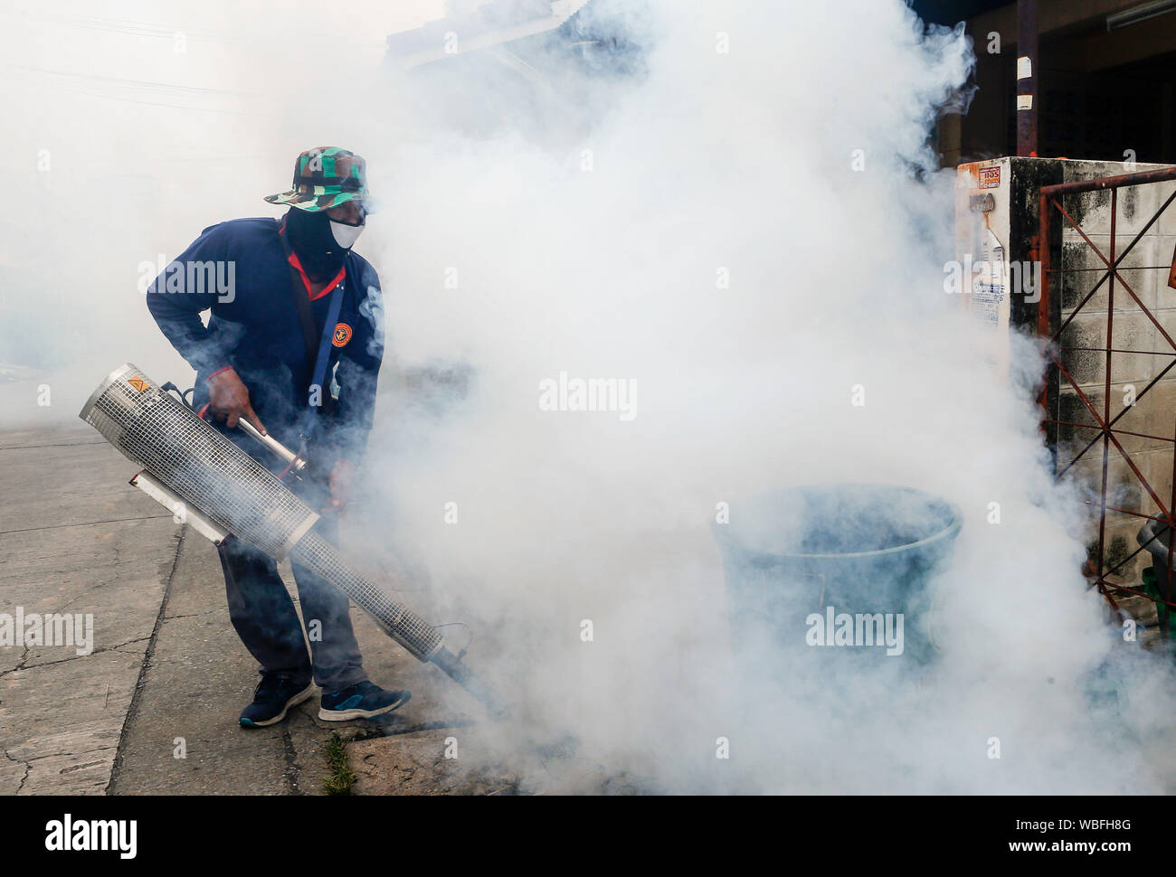Nonthaburi, Tailandia. Il 27 agosto, 2019. Un operatore sanitario fumigates per prevenire la diffusione della febbre dengue in un villaggio nella provincia di Nonthaburi, nella periferia di Bangkok. Credito: SOPA Immagini limitata/Alamy Live News Foto Stock