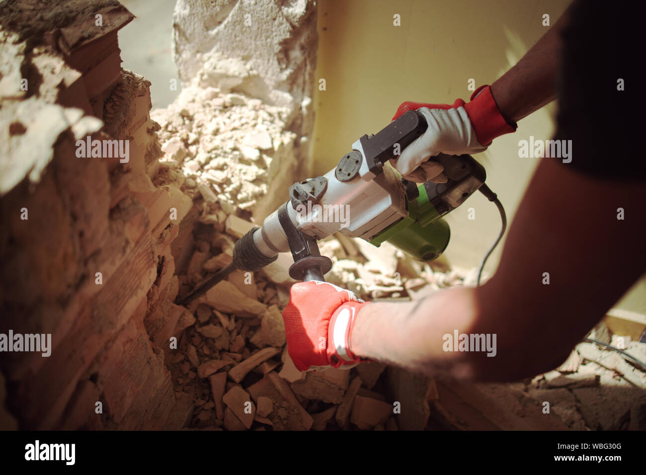 Home rinnovo, Builder con martello parete di rottura in ambienti interni Foto Stock