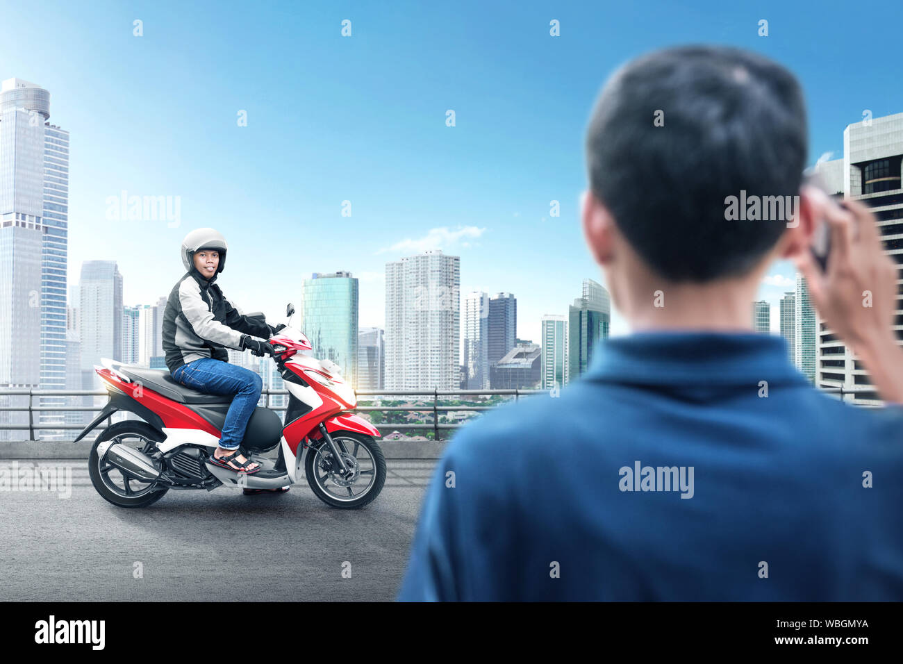 Asian motociclo taxi uomo pick up i suoi passeggeri su midtown Foto Stock