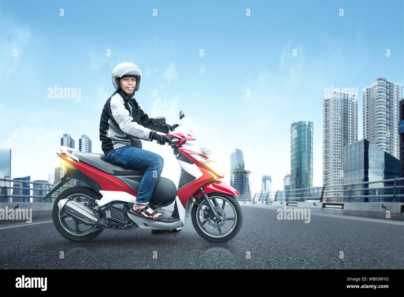 Asian motociclo taxi uomo con la sua motocicletta sulla strada asfaltata sulla midtown Foto Stock