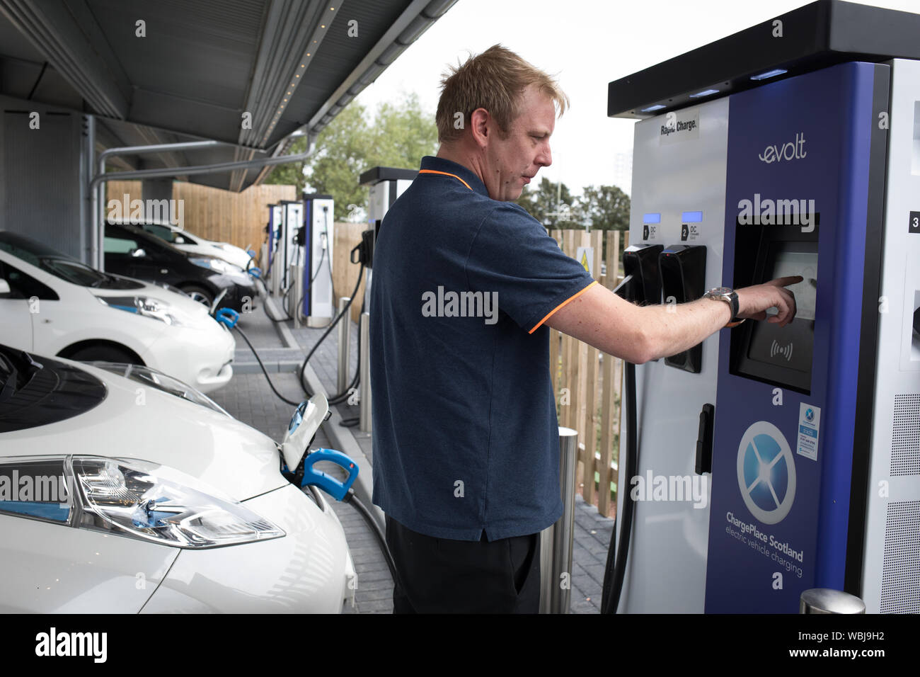 Il veicolo elettrico taxi carica presso il Princes Street la ricarica elettrica ferroviaria, uno dei tre di tali stazioni in città, in Scozia, il 14 agosto 2019. Foto Stock