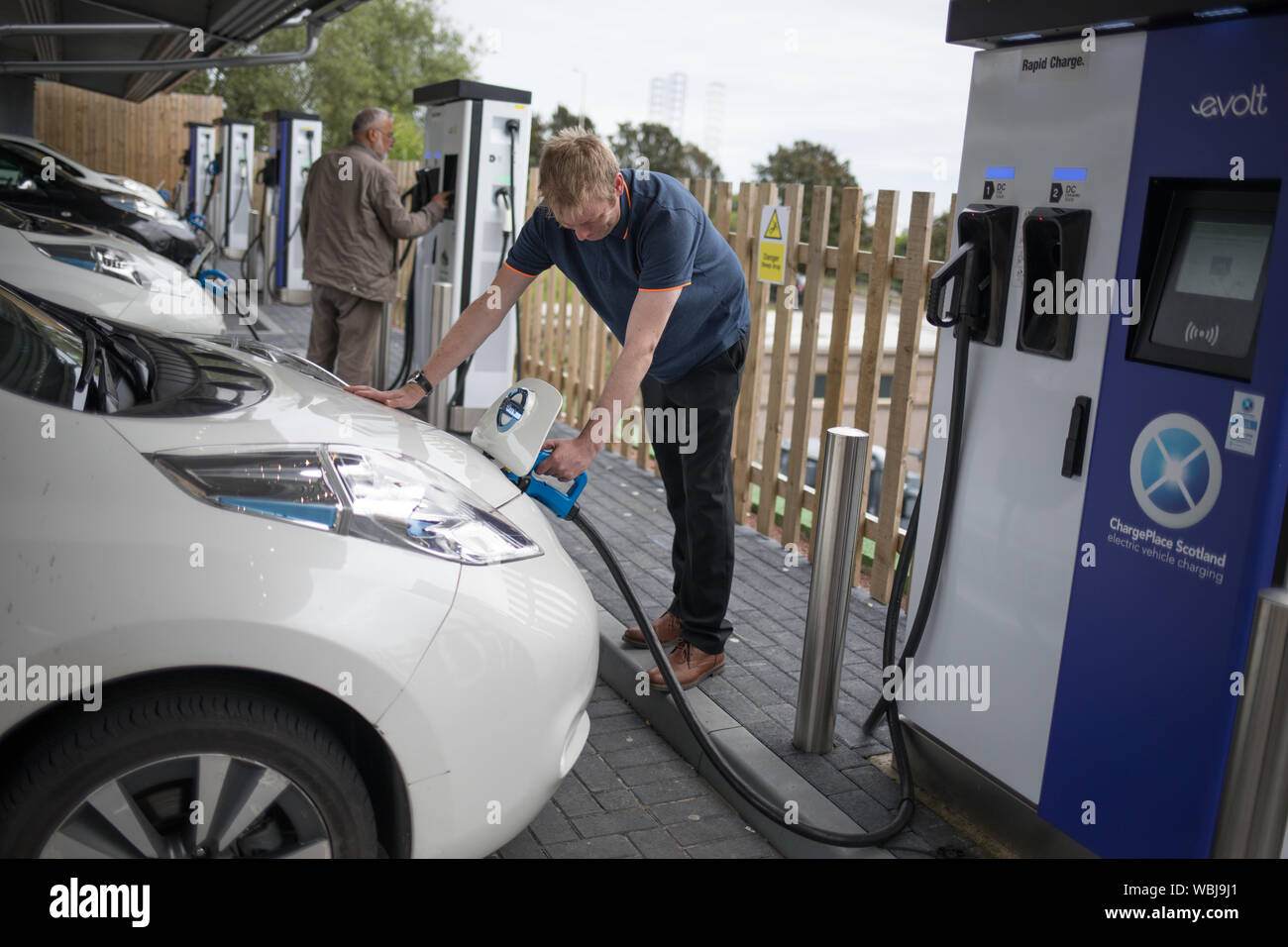 Il veicolo elettrico taxi carica presso il Princes Street la ricarica elettrica ferroviaria, uno dei tre di tali stazioni in città, in Scozia, il 14 agosto 2019. Foto Stock