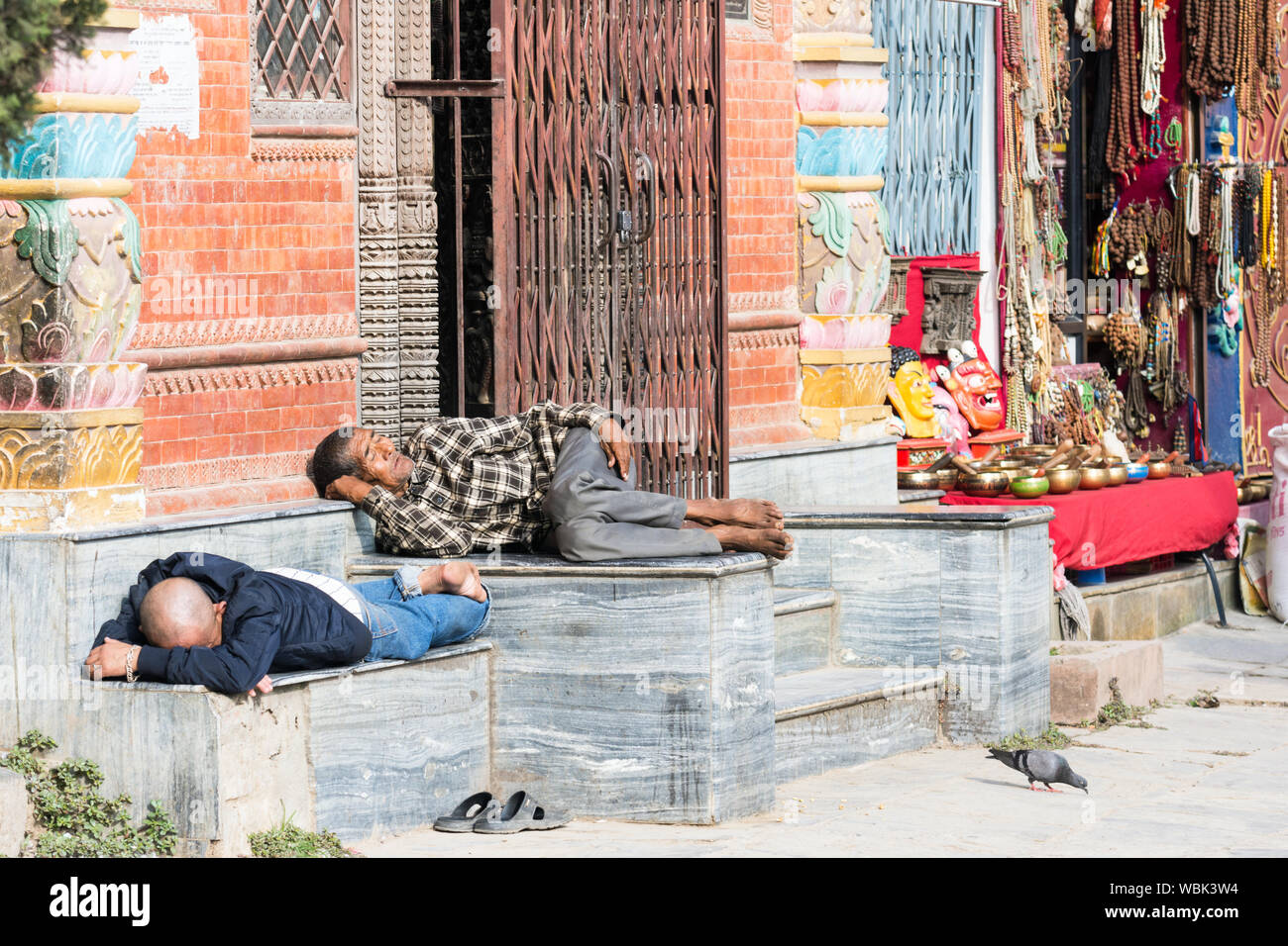 Gli uomini dormono all'aperto in piazza di Kathesimbhu stupa, Kathmandu, Nepal Foto Stock