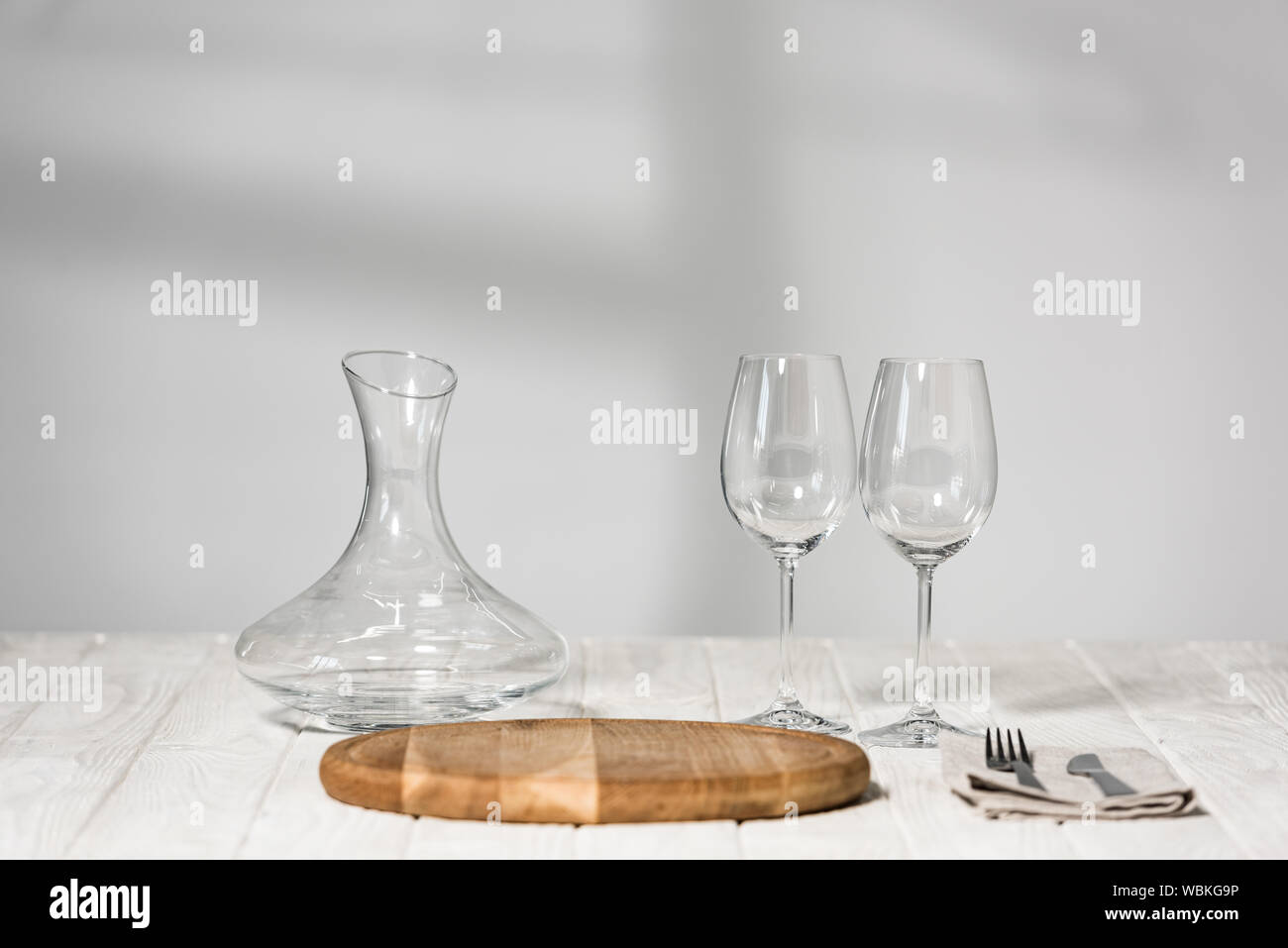 Brocca vino, bicchieri, posate e il bordo di taglio su una superficie di legno in ristorante Foto Stock