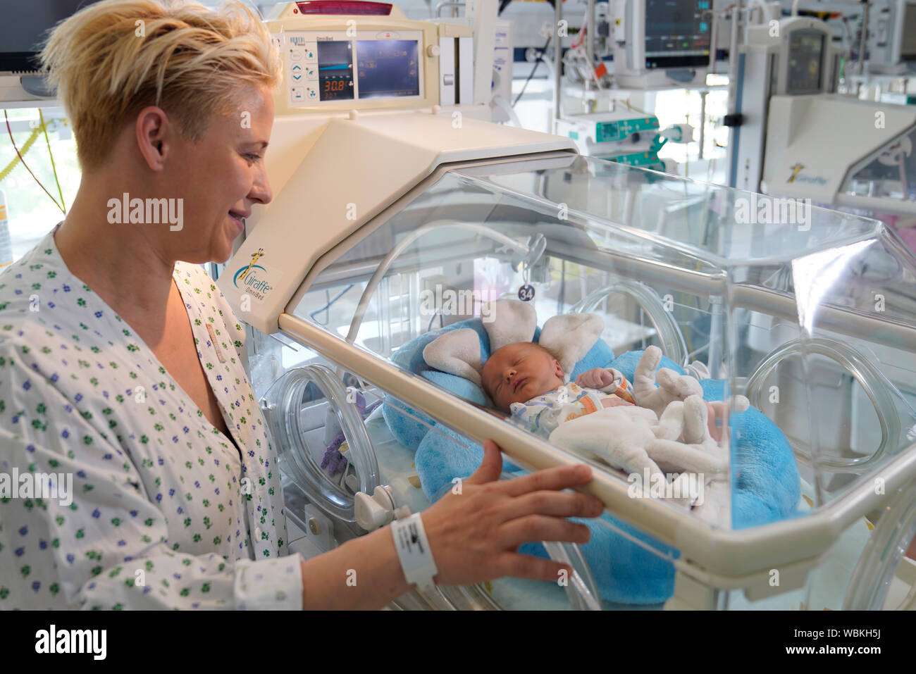 Twin madre con uno dei suoi figli in un incubatore, unità di terapia intensiva per neonati, Carlsbad, Repubblica Ceca Foto Stock