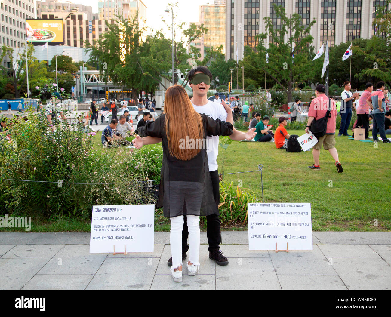 Koichi Kuwabara, 24 agosto 2019 : Giapponese Koichi Kuwabara (R) fornisce gratuitamente un abbraccio a un sud coreano donna durante un Free Hugs campaign in lui le speranze di relazioni amichevoli tra il popolo del Giappone e della Corea del Sud le persone a Gwanghwamun Square, un luogo dove un rally per denunciare il Primo Ministro giapponese Shinzo Abe e il suo regime era in corso a Seul, in Corea del Sud. Centinaia di persone hanno partecipato al rally. La Corea del Sud della sicurezza generale delle informazioni militari accordo (GSOMIA) con il Giappone è impostato per scadere il 23 novembre 2019 come Seul ha deciso il 23 agosto a non estendere GSOMIA nel mezzo di un commercio battibecco con Jap Foto Stock