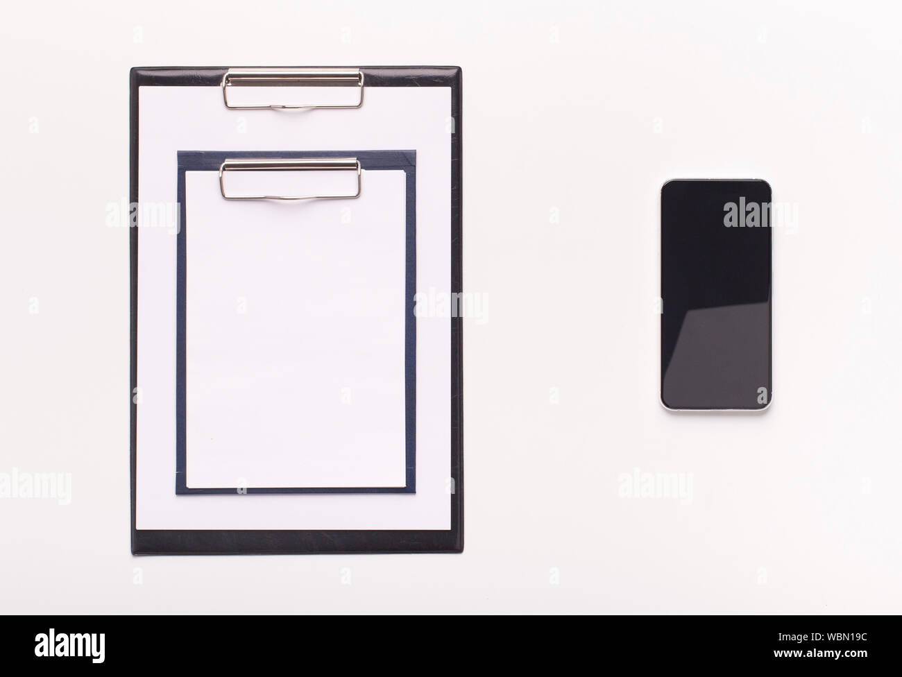Due diverse dimensioni di cartelline e telefono cellulare con schermo vuoto Foto Stock