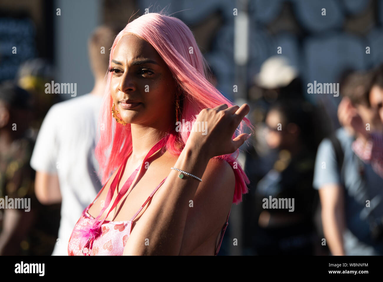 Una donna con capelli rosa che frequentano il carnevale di Notting Hill. Foto Stock
