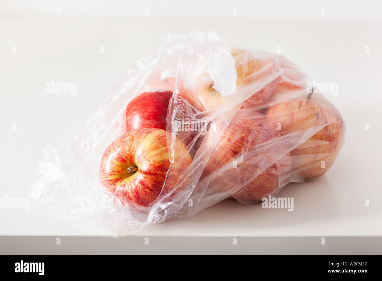 Uso singola confezione di plastica problema. le mele in un sacchetto di plastica Foto Stock