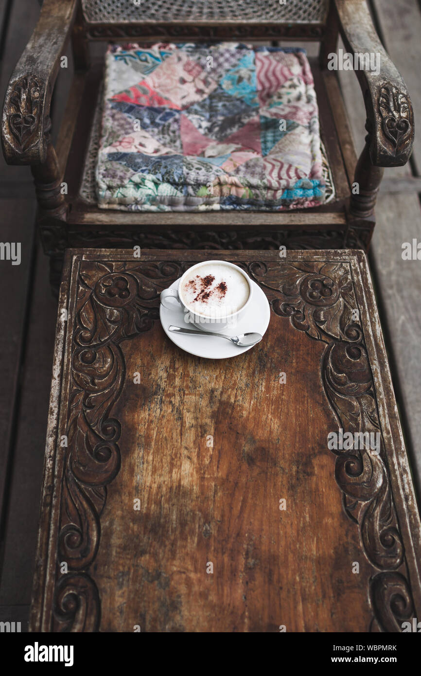 Tazza di aroma cappuccino su vintage tavolo in legno fatti a mano, carving, texture in stile Bali Foto Stock