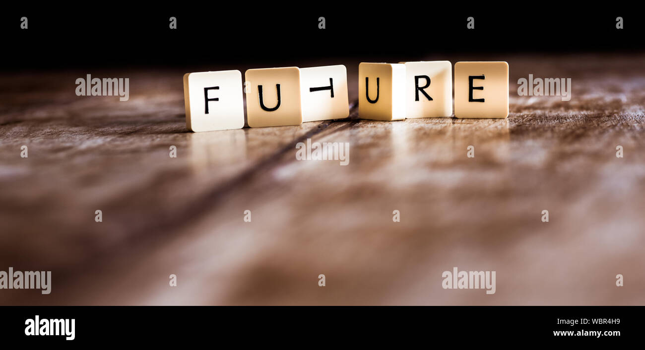 Futuro parola fatta di formelle in legno scuro dello sfondo Foto Stock