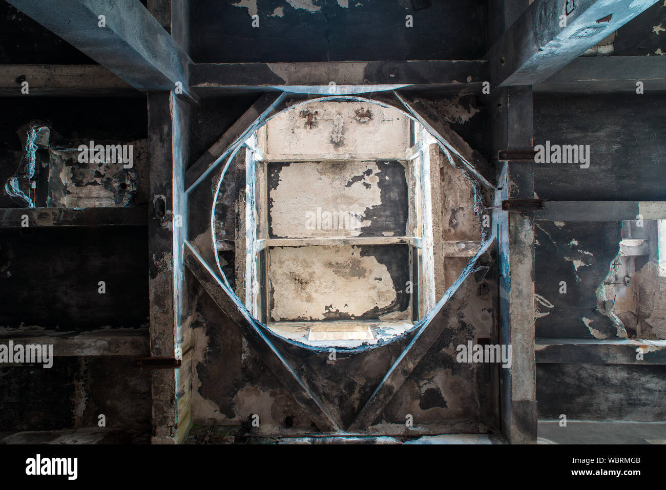 Il foro nel pavimento della fabbrica in rovina Foto Stock