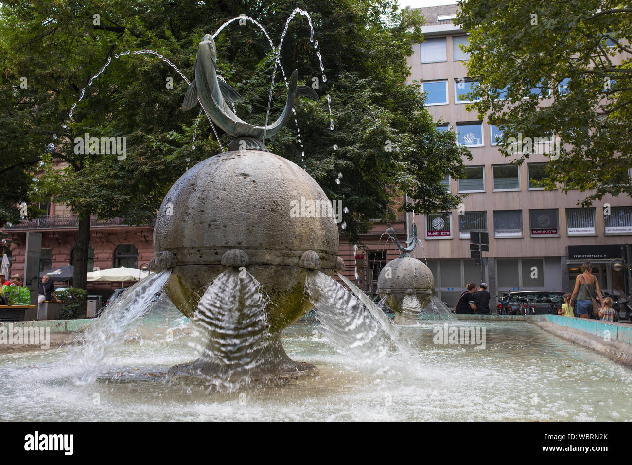 Fontana con pesci 'Fischtorbrunnen' e persone in background, Mainz, Germania Foto Stock