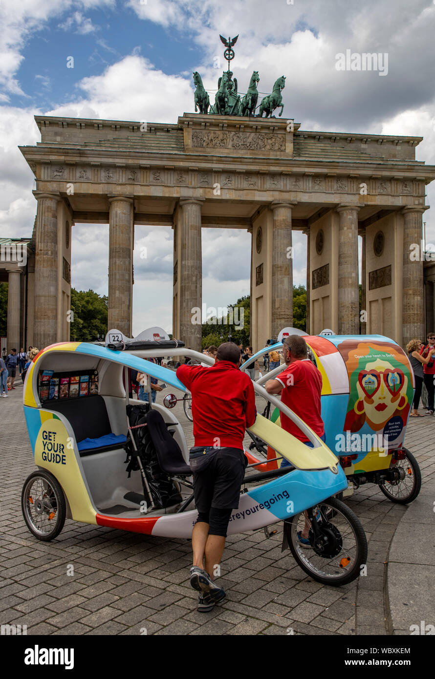 Turisti e visitatori presso la Porta di Brandeburgo, risciò bicicletta piloti in attesa per i clienti, Berlino Foto Stock