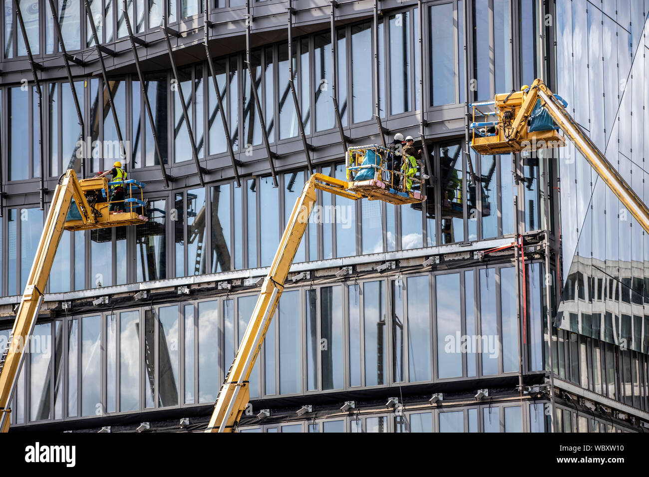 Sito in costruzione, facciate il lavoro sul nuovo edificio cubo, presso la stazione principale, lavoro con piattaforme elevatrici, Berlino, Foto Stock