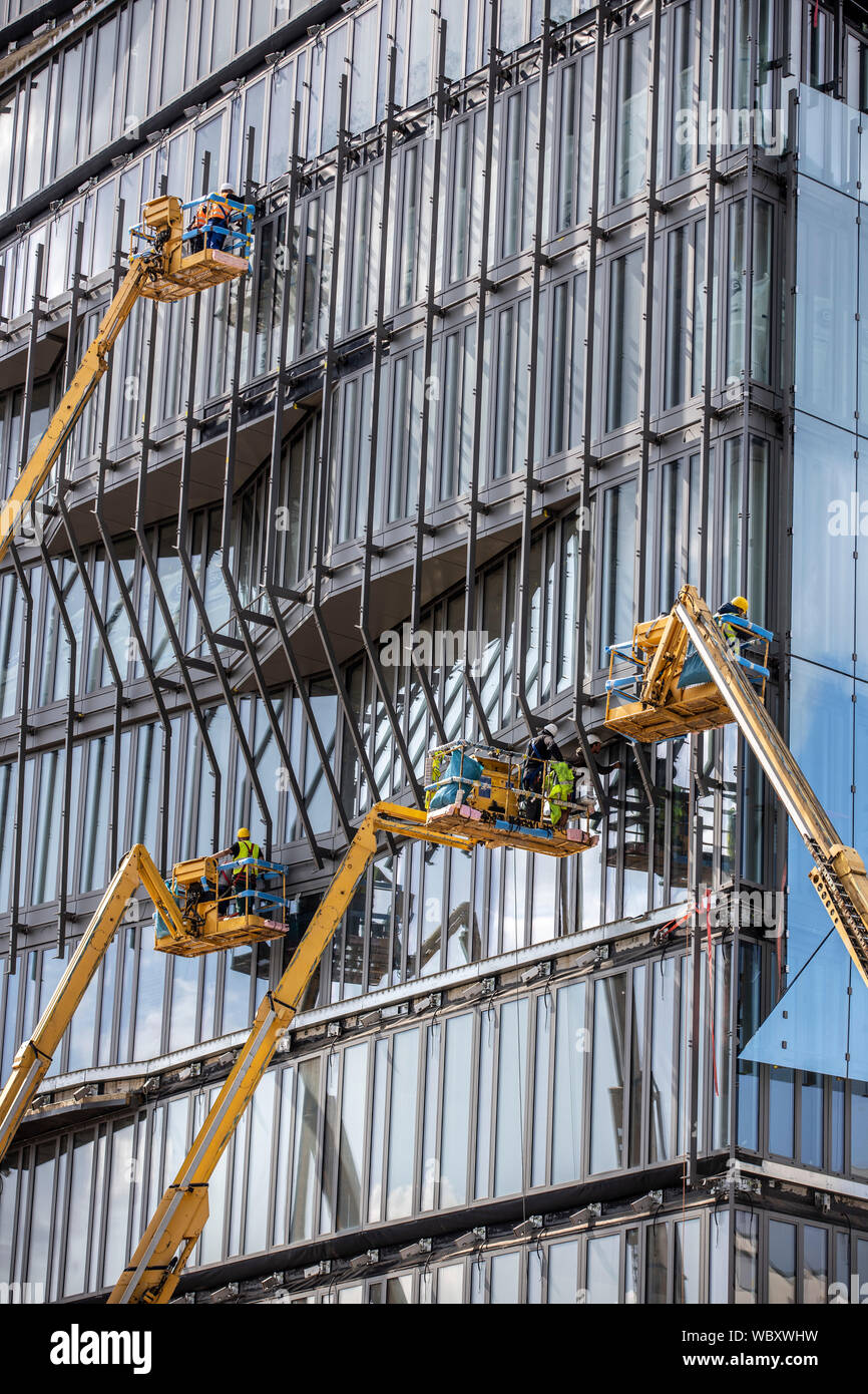 Sito in costruzione, facciate il lavoro sul nuovo edificio cubo, presso la stazione principale, lavoro con piattaforme elevatrici, Berlino, Foto Stock