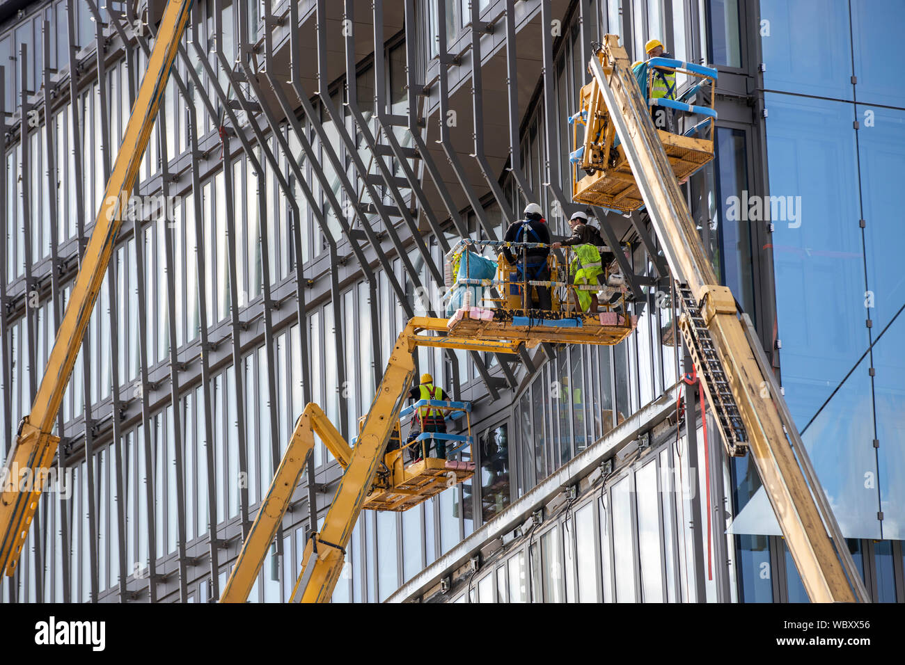 Sito in costruzione, facciate il lavoro sul nuovo edificio cubo, presso la stazione principale, lavoro con piattaforme elevatrici, Berlino, Foto Stock
