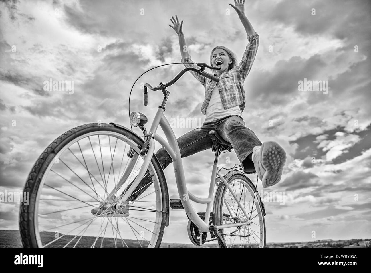 La libertà e la gioia. La donna si sente libero mentre vi piace andare in bicicletta. Più soddisfacente in forma di auto trasporto. Escursioni in bicicletta dà la sensazione di libertà e indipendenza. La ragazza corse in bicicletta sullo sfondo del cielo. Foto Stock