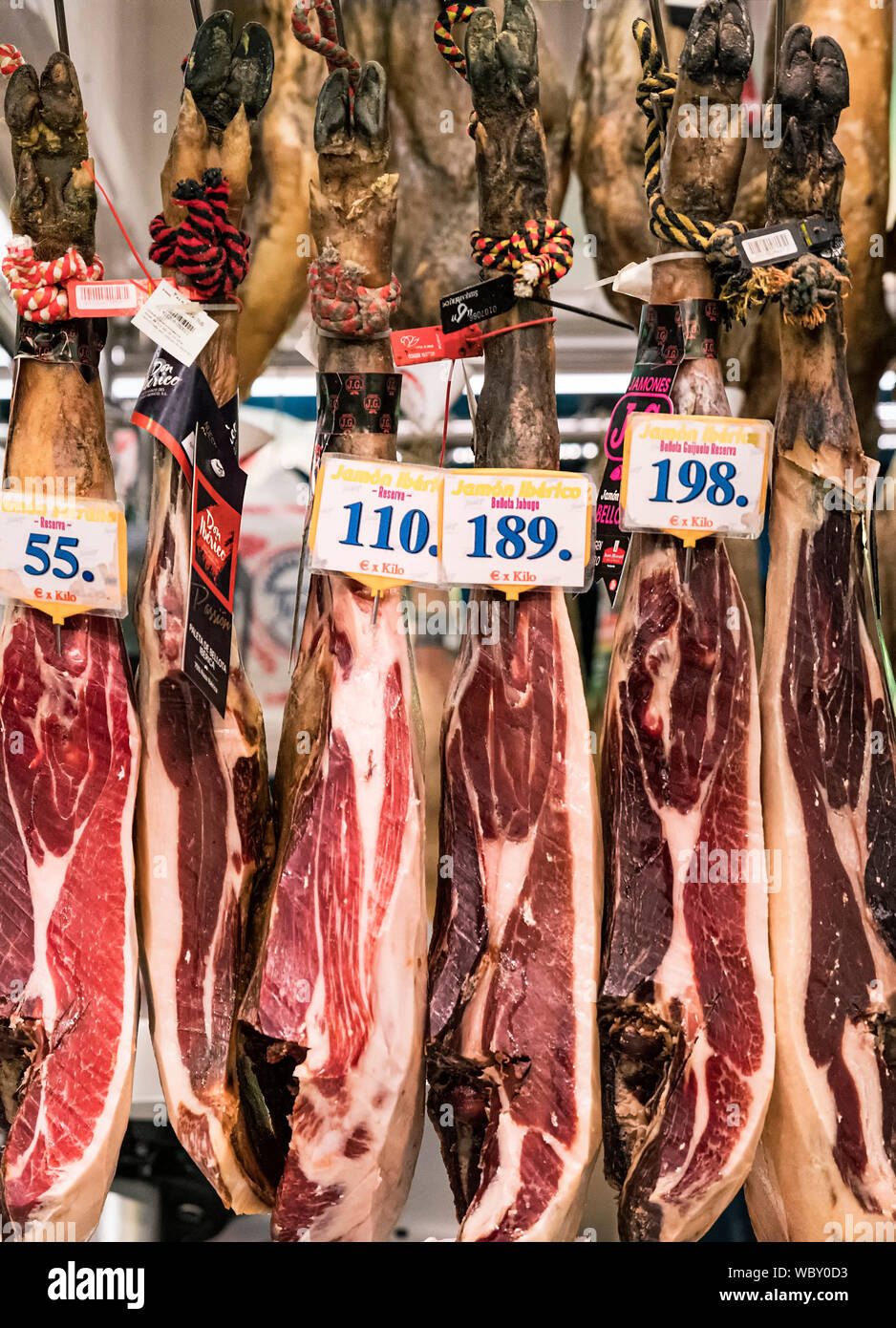 Prosciutto cotto le gambe in una macelleria, al Mercato della Boqueria, Barcelona, Spagna. Foto Stock