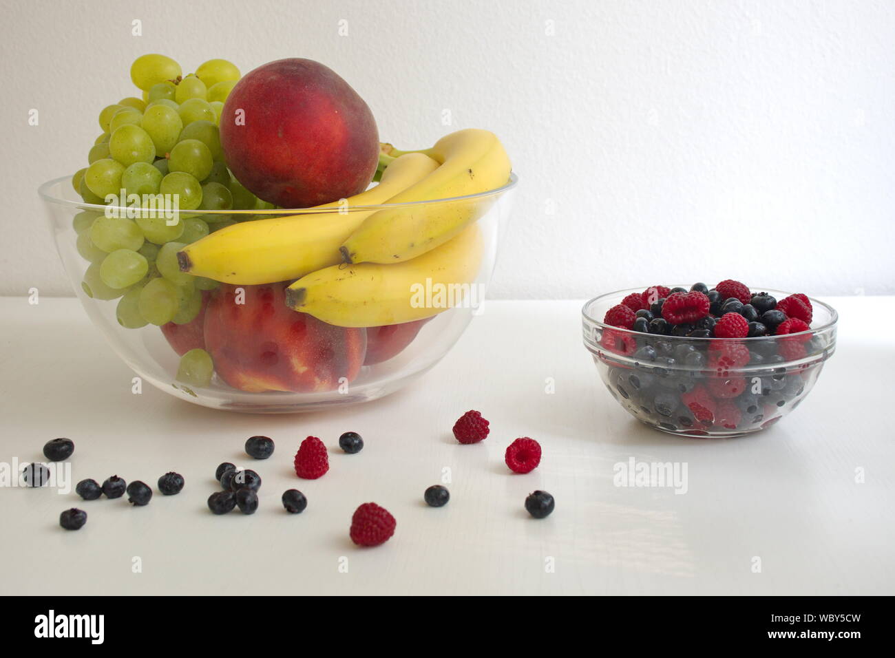 Vaschetta trasparente con vari frutti sullo sfondo bianco Foto Stock