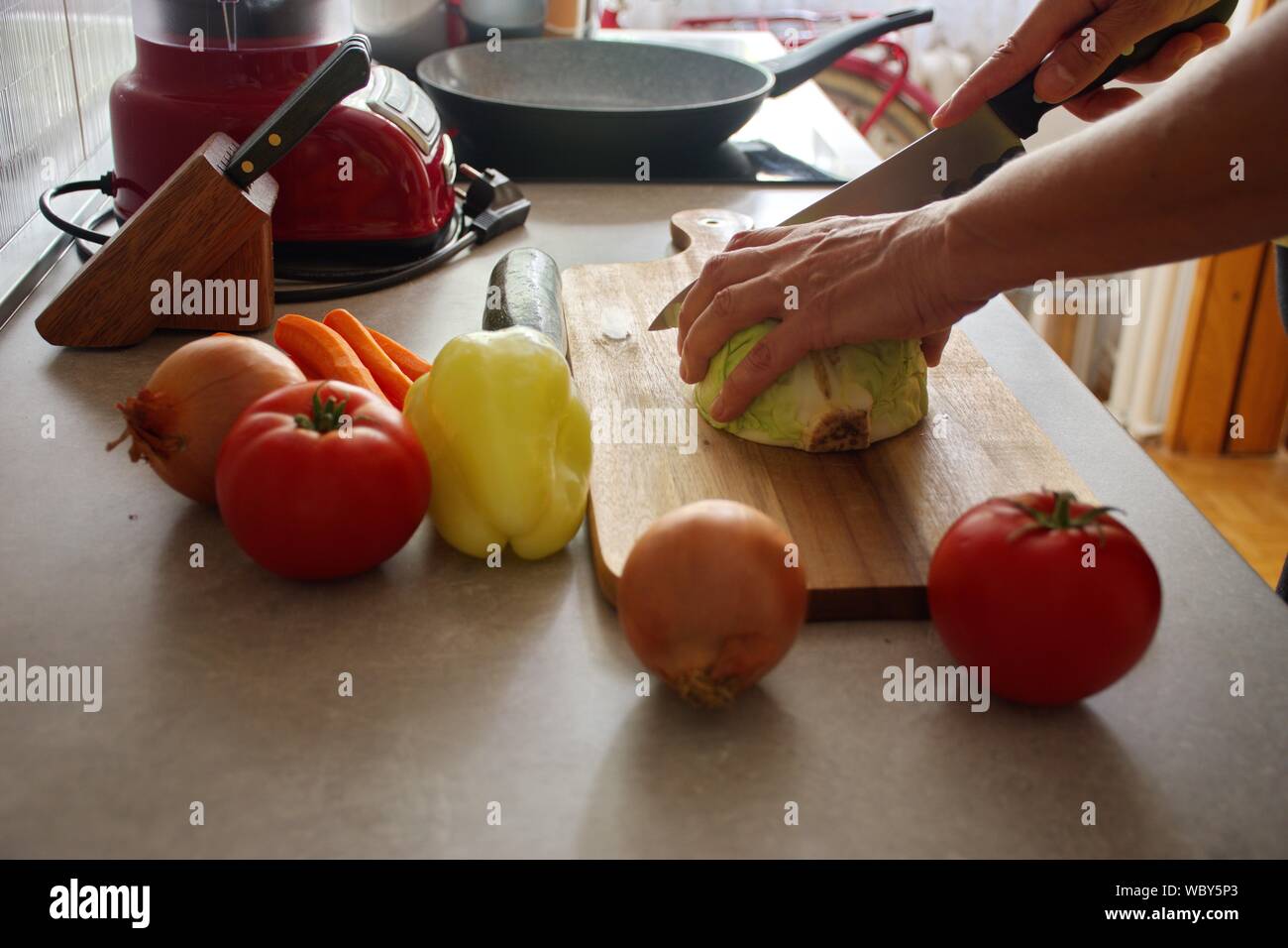 Sezione mediana della donna matura preparare verdura in cucina Foto Stock