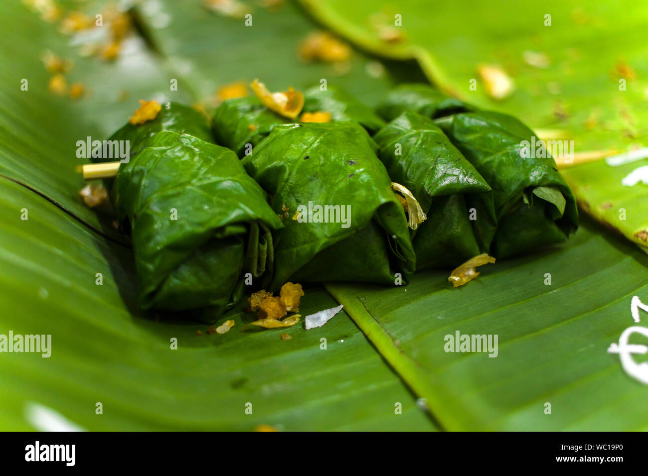 Thai dessert di riso appiccicoso, latte di cocco e banana avvolto in foglie di banano alta risoluzione galleria di immagini. Foto Stock
