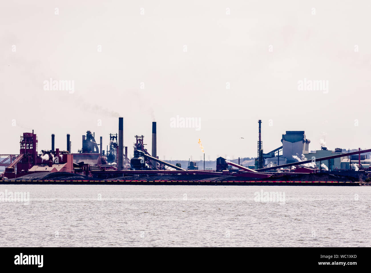 HAMILTON, Ontario, Canada - 21 Aprile 2018: Grandi di produzione di acciaio strutture occupano le rive del porto di Hamilton. Foto Stock