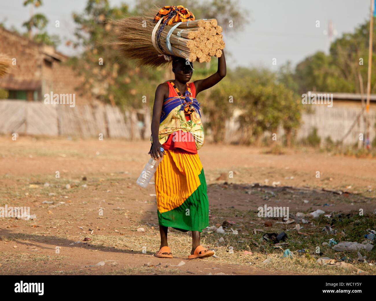 TORIT, SUD SUDAN-febbraio 20 2013: donna non identificato trasporta un carico pesante sulla sua testa in Torit, Sud Sudan. Foto Stock