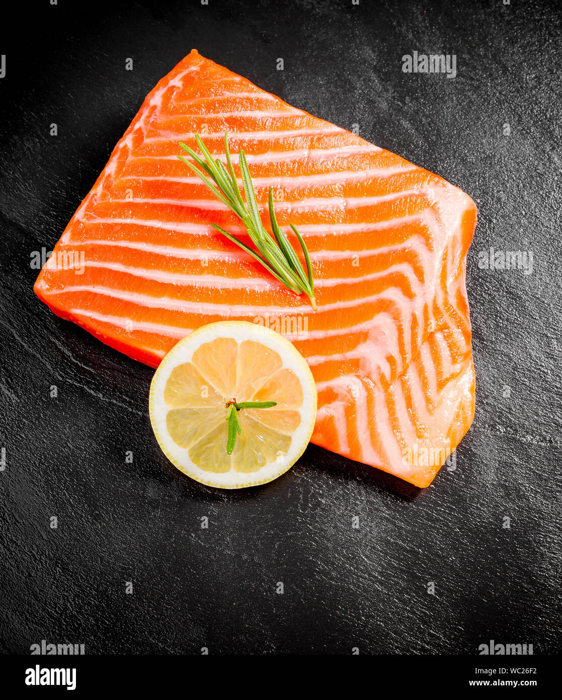 Succosa di filetto di salmone su nero ardesia piastra, vista dall'alto Foto Stock