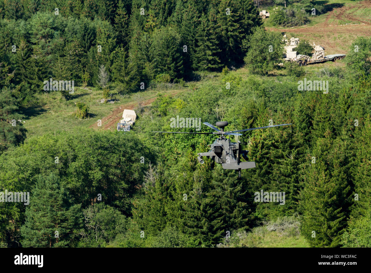 Un esercito AH-64 Attacco Apache elicottero appartenenti al primo squadrone, 6° reggimento di cavalleria, 1a combattere la Brigata Aerea, 1a divisione di fanteria, pattuglie della foresta durante la simulazione di una missione come parte della produzione combinata di risolvere XII su una gamma a Hohenfels Area Formazione, Germania, Agosto 21, 2019. Risolvere combinato è un biennale U.S. Esercito in Europa e il settimo Esercito di formazione comando-led esercizio destinato a valutare e certificare la disponibilità e l'interoperabilità di noi le forze mobilitate in Europa a sostegno di Atlantic risolvere. (U.S. Esercito foto di Sgt. Geremia boschi) Foto Stock