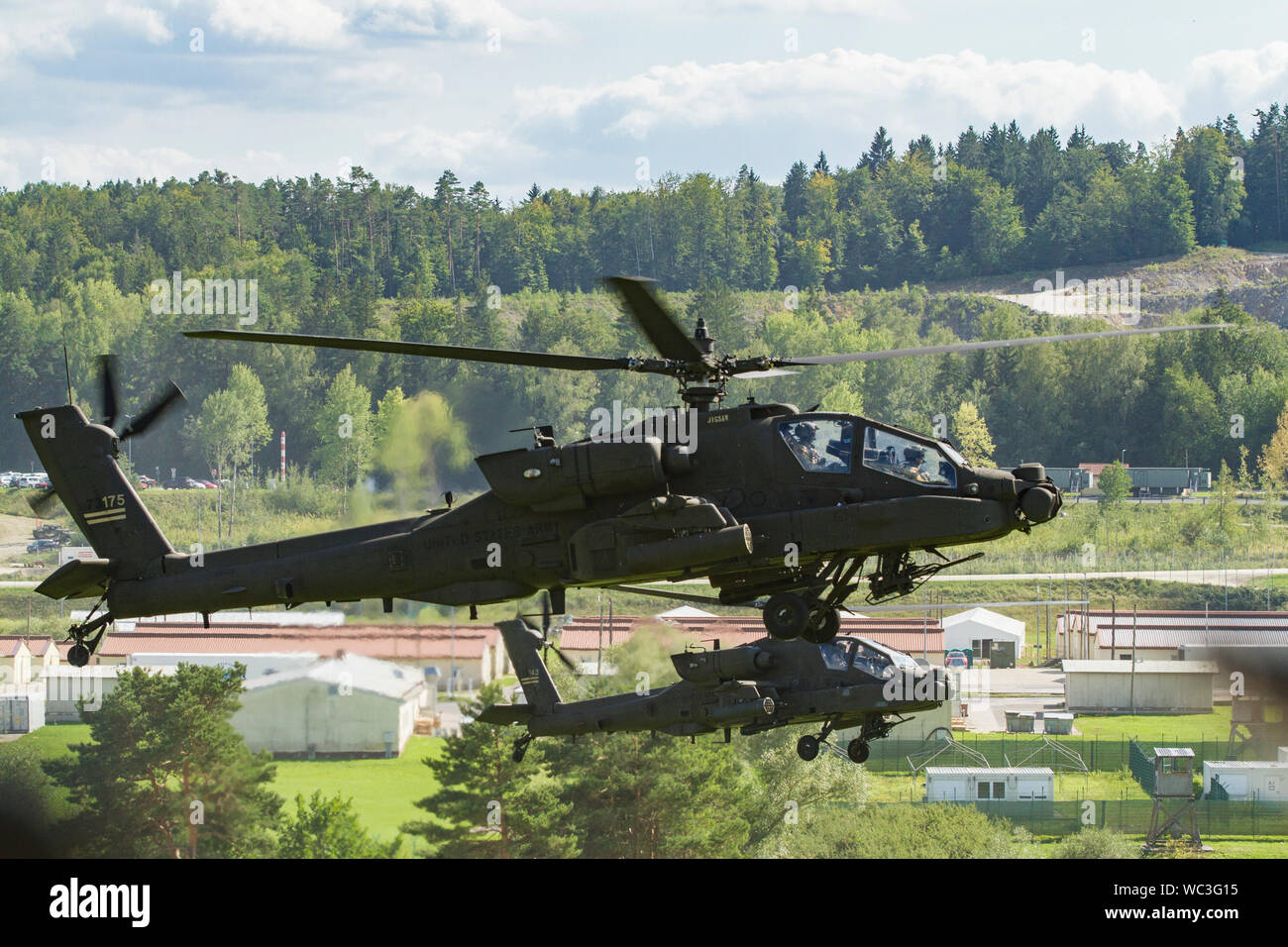 Esercito AH-64 Apache elicotteri da attacco appartenenti al primo squadrone, 6° reggimento di cavalleria, 1a combattere la Brigata Aerea, 1a divisione di fanteria, passare il puntatore del mouse nella formazione tecnica per la simulazione di una missione come parte della produzione combinata di risolvere XII su una gamma a Hohenfels Area Formazione, Germania, Agosto 16, 2019. Risolvere combinato è un biennale U.S. Esercito in Europa e il settimo Esercito di formazione comando-led esercizio destinato a valutare e certificare la disponibilità e l'interoperabilità di noi le forze mobilitate in Europa a sostegno di Atlantic risolvere. (U.S. Esercito foto di Sgt. Geremia boschi) Foto Stock