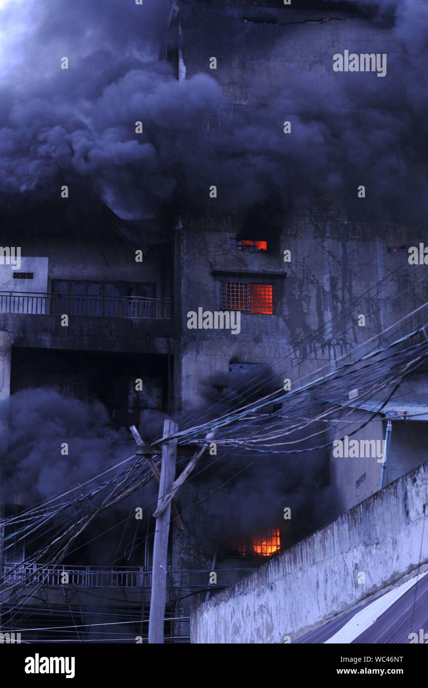 Il fumo e fiamme ondeggianti da un materasso factory fire, Steung Meanchey, Phnom Penh Cambogia. Credito: Kraig Lieb Foto Stock