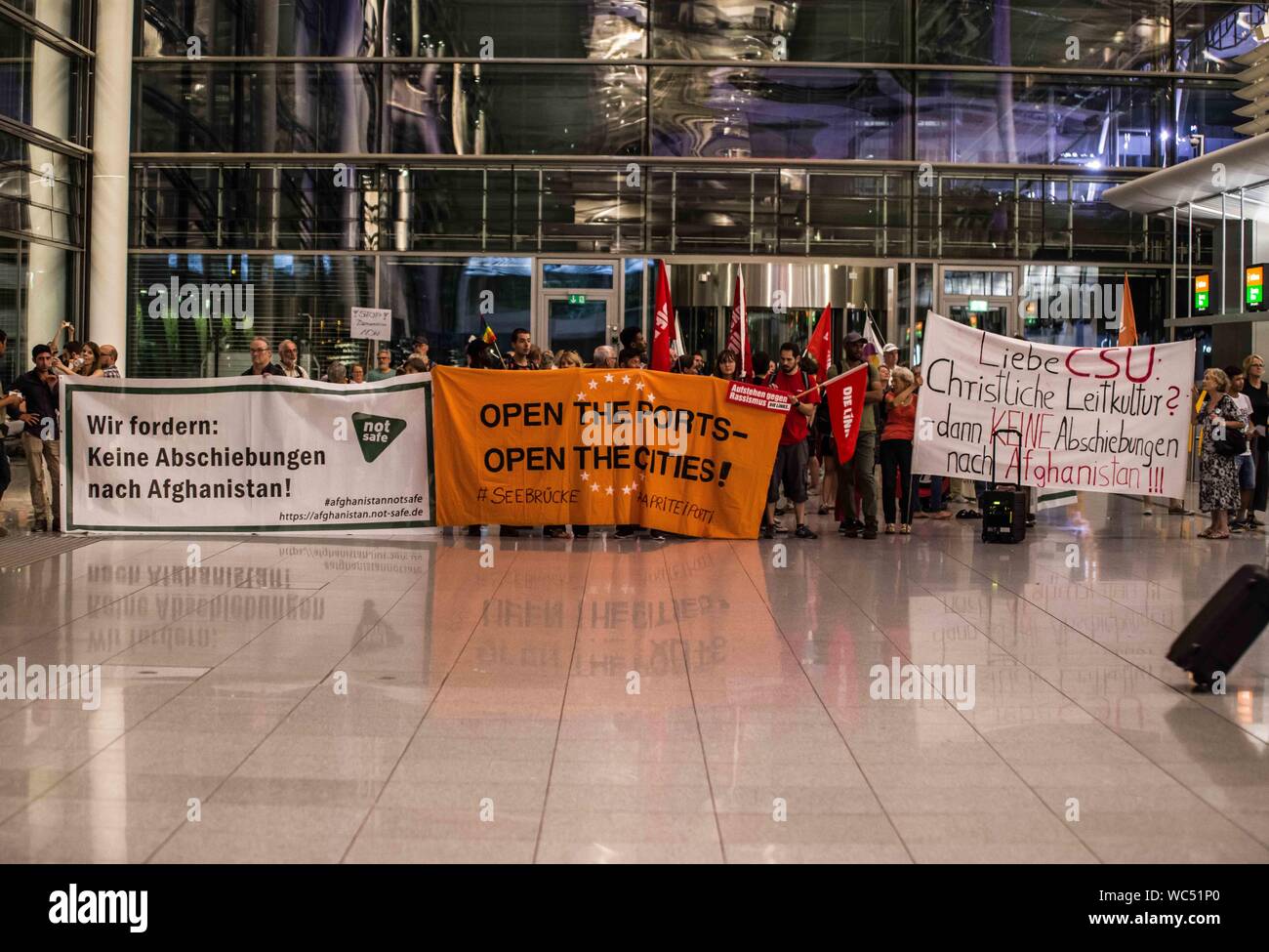 Monaco di Baviera, Germania. Il 27 agosto, 2019. Monaco di Baviera, Germania. Il 27 agosto, 2019. ''Apertura delle frontiere per i rifugiati". In coincidenza con una deportazione di massa dalla Germania in Afghanistan, 100 rifugiati, i migranti e gli attivisti ha organizzato una manifestazione di protesta contro la Germania della politica dei rifugiati presso l' Aeroporto Internazionale di Monaco di Baviera. Tra le critiche includono l'uso di Ankerzentren (centri di ancoraggio) progettato per sequestrare i rifugiati e i migranti lontano dalla società, asilo sleale delle valutazioni effettuate dal BAMF, il Dublin III Convenzione e il controverso 'safe terra d origine'' determinazioni che sono state utilizzate per accelerare deportatio Foto Stock