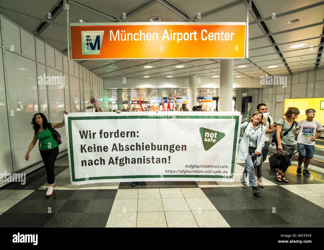 Monaco di Baviera, Germania. Il 27 agosto, 2019. ''Abbiamo domanda no deportazioni in Afghanistan''. In coincidenza con una deportazione di massa dalla Germania in Afghanistan, 100 rifugiati, i migranti e gli attivisti ha organizzato una manifestazione di protesta contro la Germania della politica dei rifugiati presso l' Aeroporto Internazionale di Monaco di Baviera. Tra le critiche includono l'uso di Ankerzentren (centri di ancoraggio) progettato per sequestrare i rifugiati e i migranti lontano dalla società, asilo sleale delle valutazioni effettuate dal BAMF, il Dublin III Convenzione e il controverso 'safe terra d origine'' determinazioni che sono stati utilizzati per accelerare le deportazioni in guerra Foto Stock