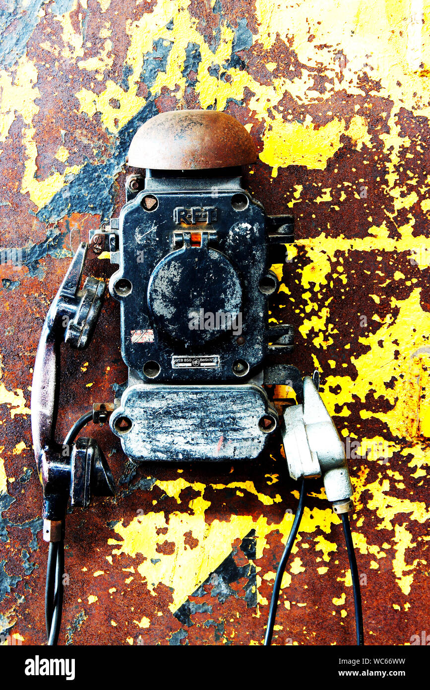 Vecchio muro telefono con un ricevitore in una fabbrica Foto Stock