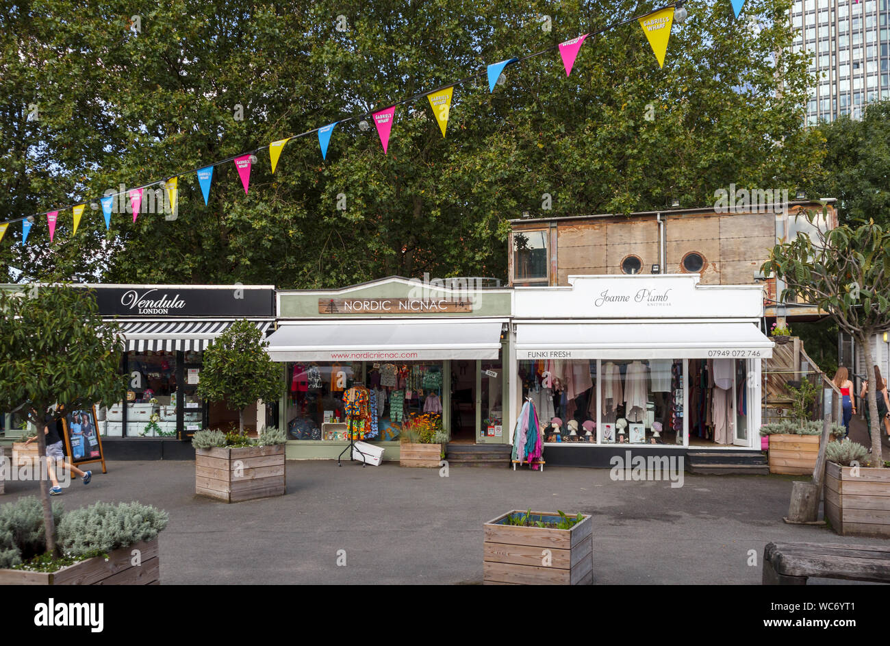 Piccoli i vestiti e le botteghe artigiane e boutique in Gabriel's Wharf a Southwark, Londra SE1 sulla riva sud dell'argine del fiume Tamigi Foto Stock