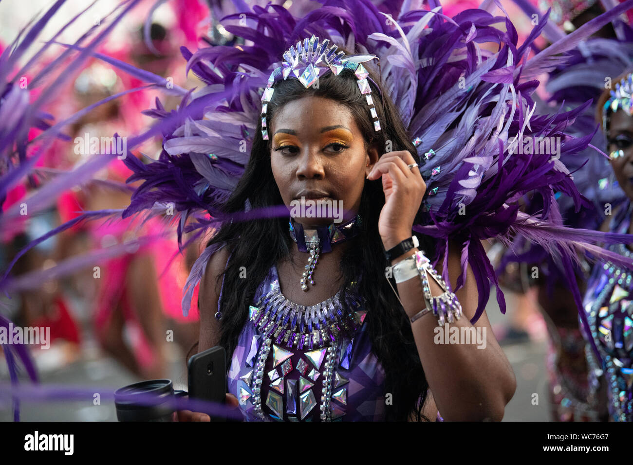 Ballerino femmina indossando piume al carnevale di Notting Hill a Londra, la più grande strada di carnevale in Europa Foto Stock