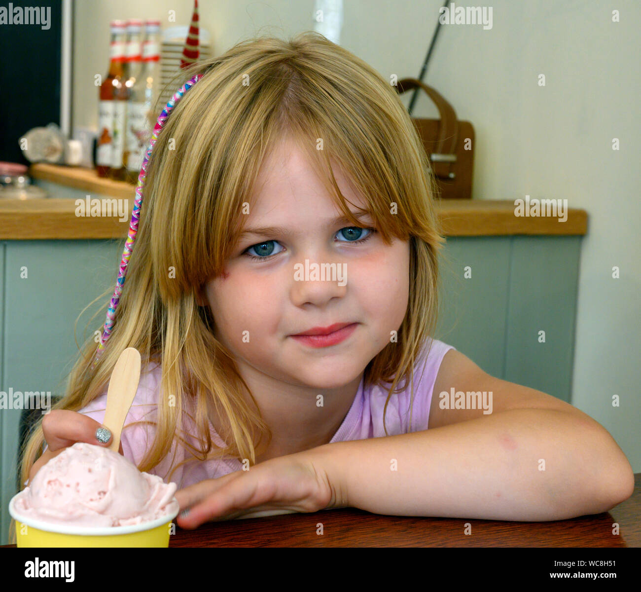 Giovane ragazza inglese - 5 anni - circa per gustare un gelato. Foto Stock