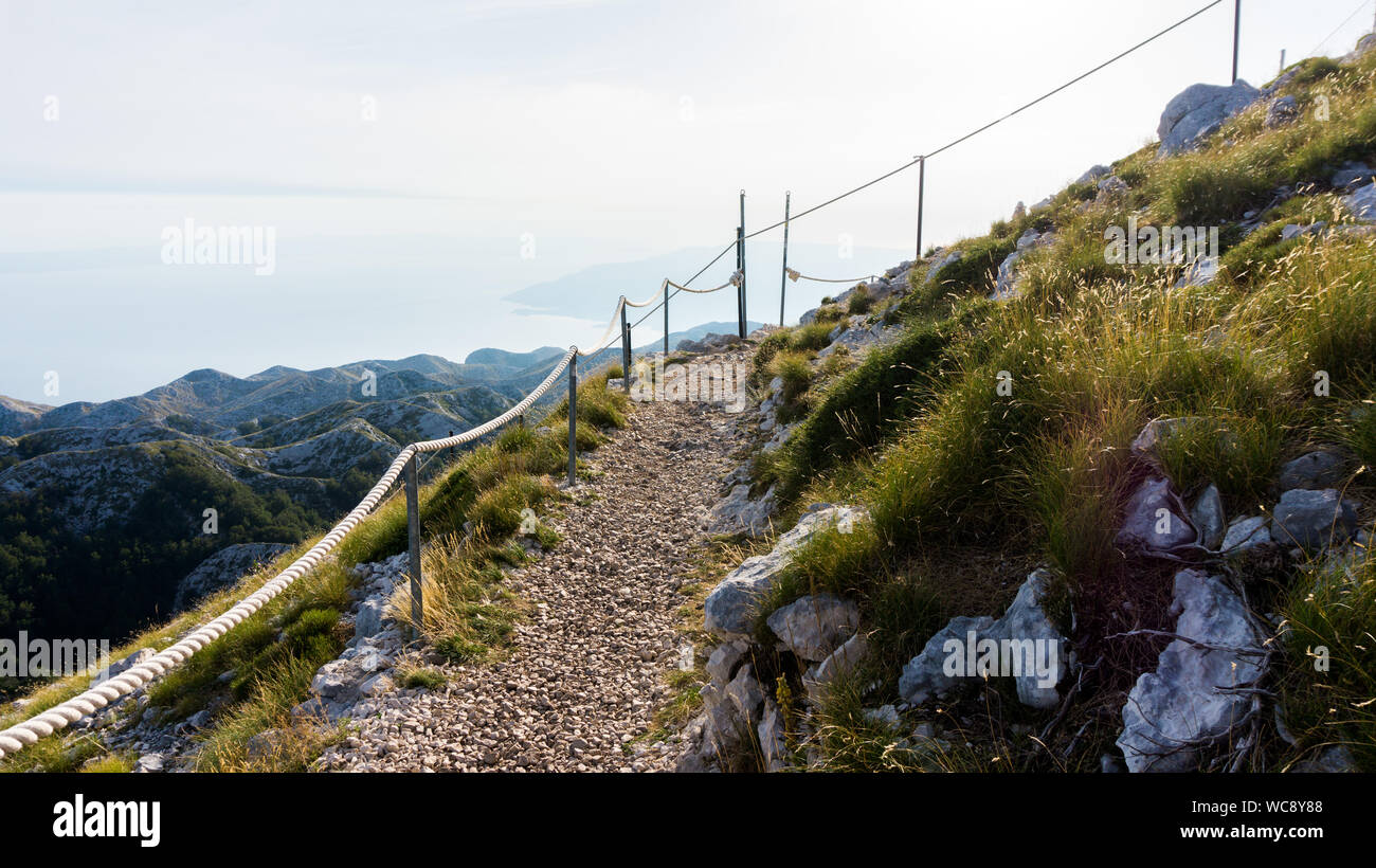Via sassosa con fune recinzione in montagna Biokovo, Riviera di Makarska, Croazia Foto Stock