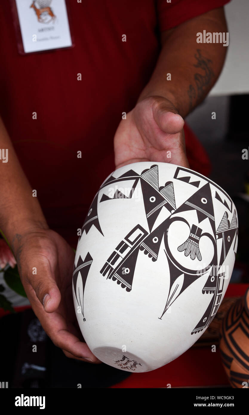 Franklin Peters, un nativo americano potter da Acoma Pueblo, detiene uno dei suoi dipinti a mano pentole a Santa Fe il mercato indiano a Santa Fe, New Mexico. Foto Stock