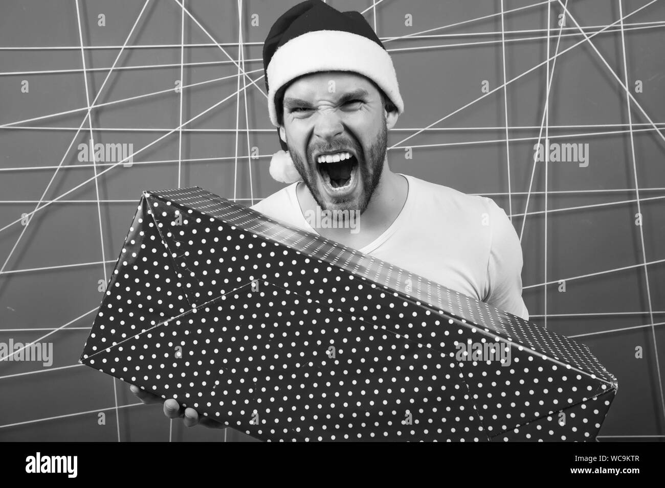 La consegna di regali di Natale. uomo felice in santa hat tenere presente di natale. La mattina prima di Natale. l uomo si godono la vacanza. Buon Natale e Buone Feste. Vacanze invernali vendite. Foto Stock