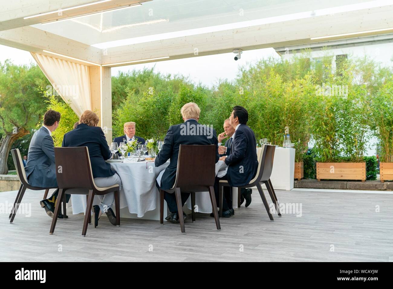 I leader del mondo la cena sotto la massiccia Biarritz faro durante i leader del G7,' la cena Agosto 24, 2019 a Biarritz, Francia. Seduti da sinistra a destra sono: il Cancelliere tedesco Angela Merkel e il primo ministro canadese Justin Trudeau, U.S. Presidente Donald Trump, Presidente del Consiglio europeo Donald Tusk, Primo Ministro giapponese Shinzo Abe e del Primo Ministro britannico Boris Johnson. Foto Stock