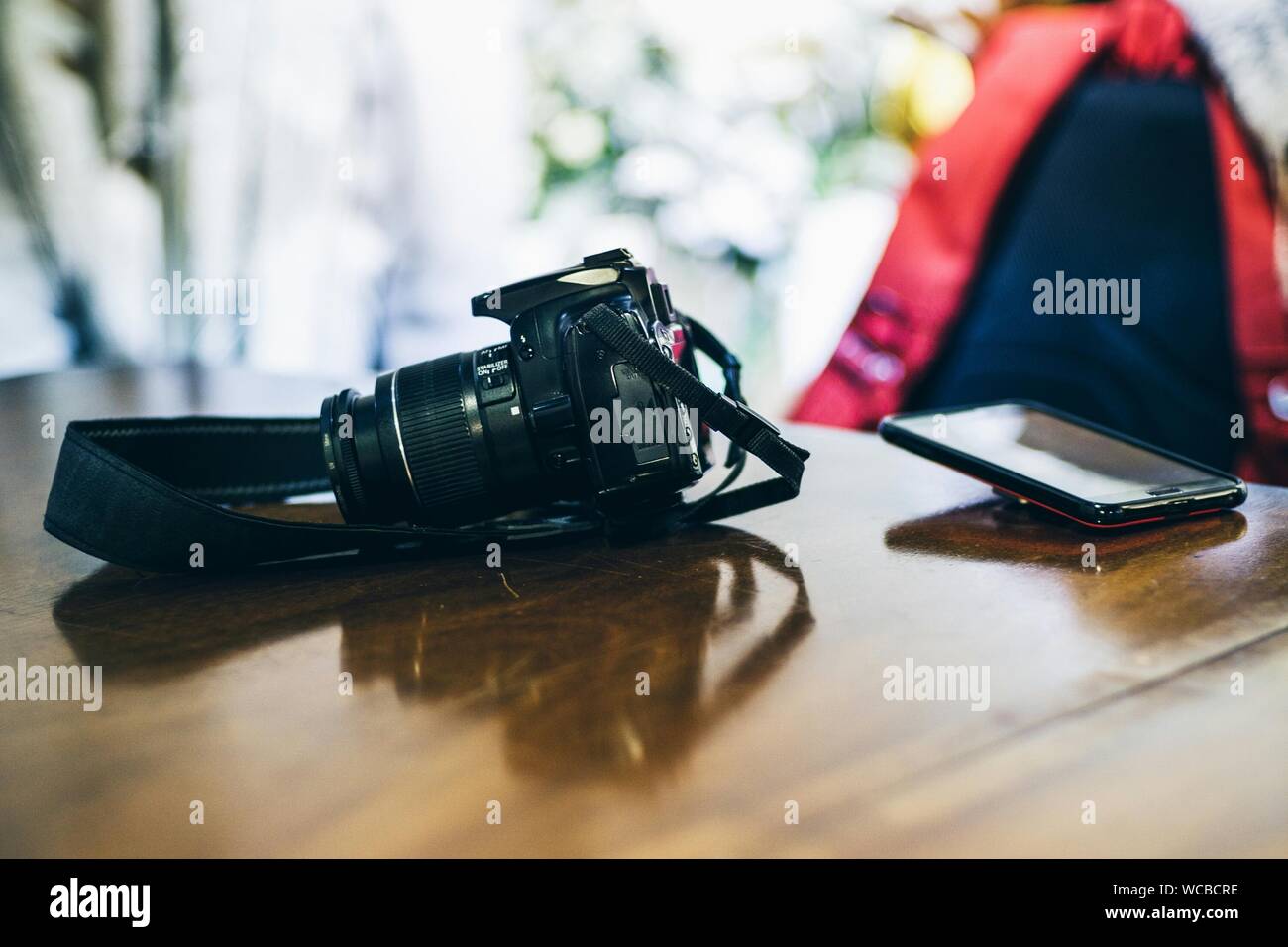 Digital Single Lens Reflex e il telefono cellulare sul tavolo Foto Stock